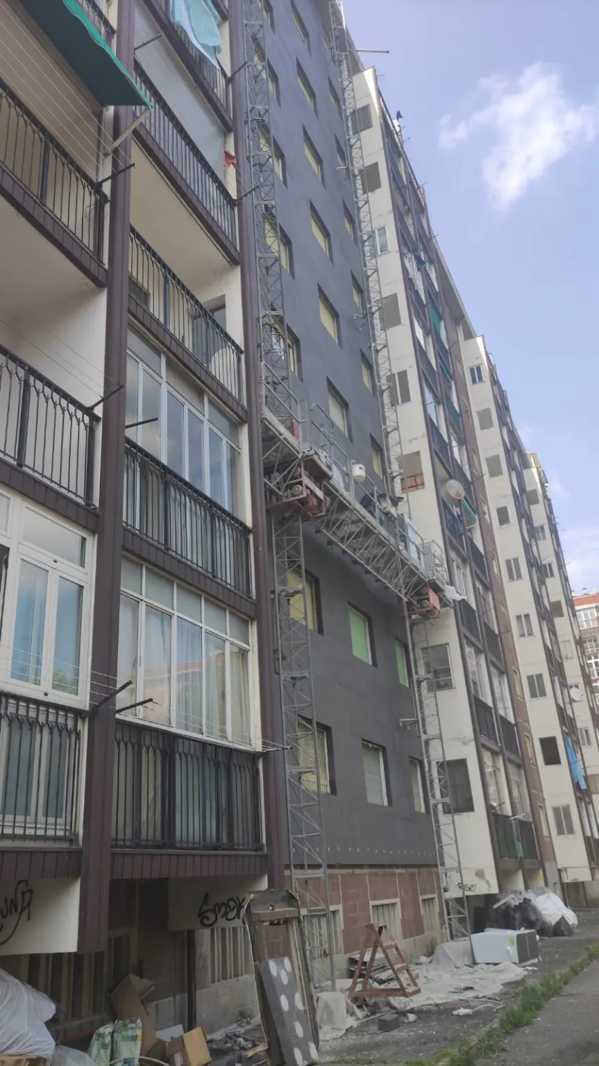 Facciata di un edificio residenziale con balconi e materiali di cantiere alla base