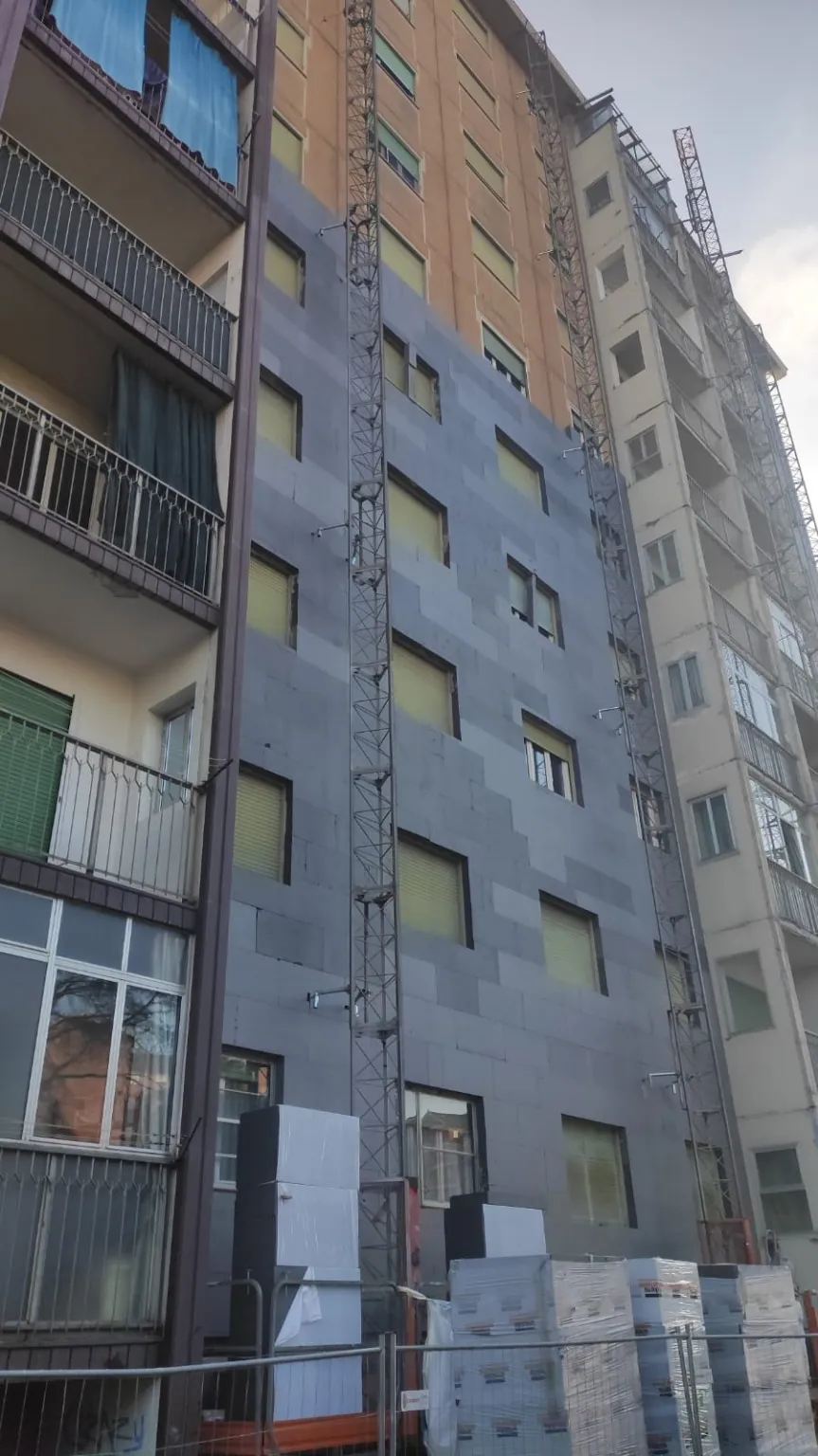 Facciata in lavorazione con pannelli, finestre e piattaforma di cantiere