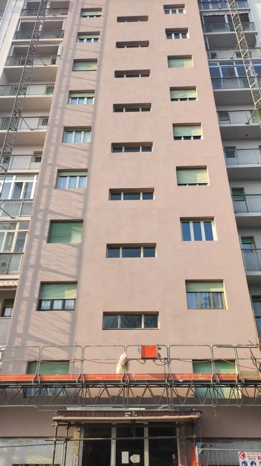 Facciata condominiale durante i lavori, con piattaforma alla base