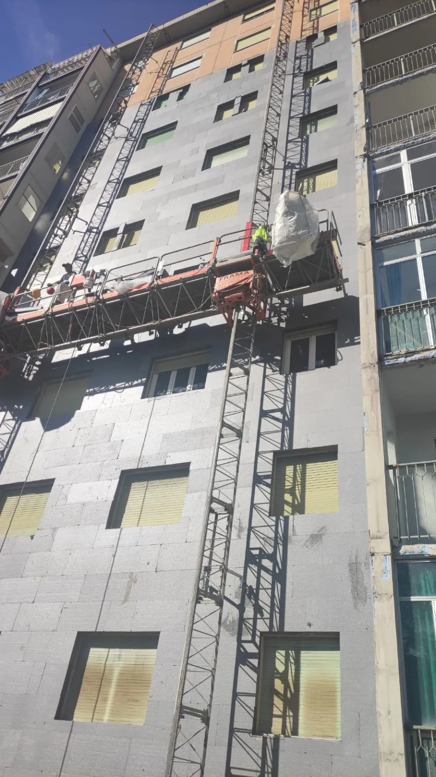 Facciata in lavorazione con superfici rasate e piattaforma autosollevante