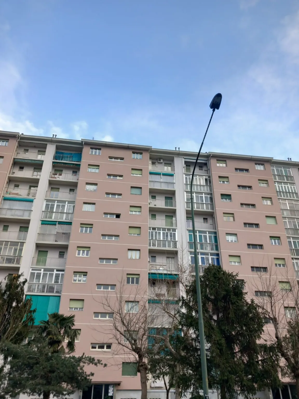 Prospetto di un edificio residenziale con facciata rosa e balconi